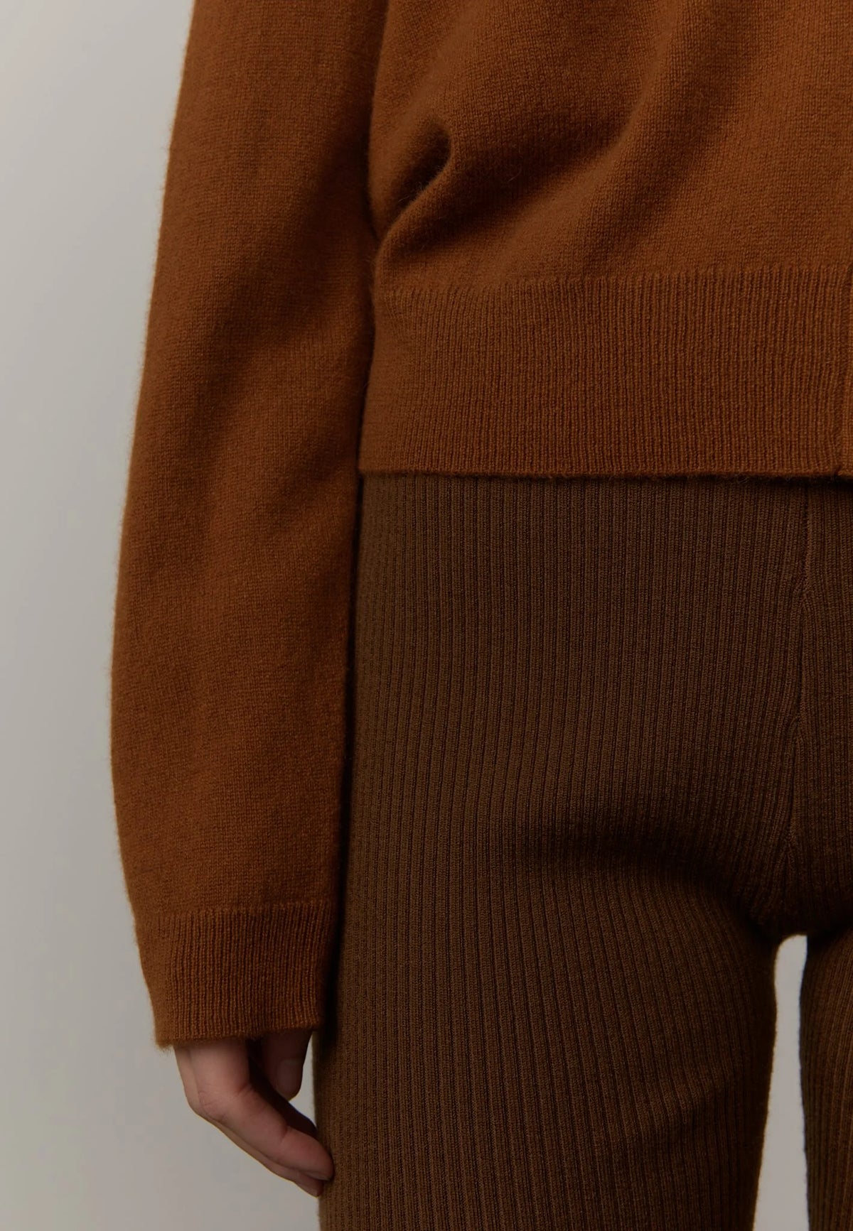 Brown sweater and pants set on a plain background