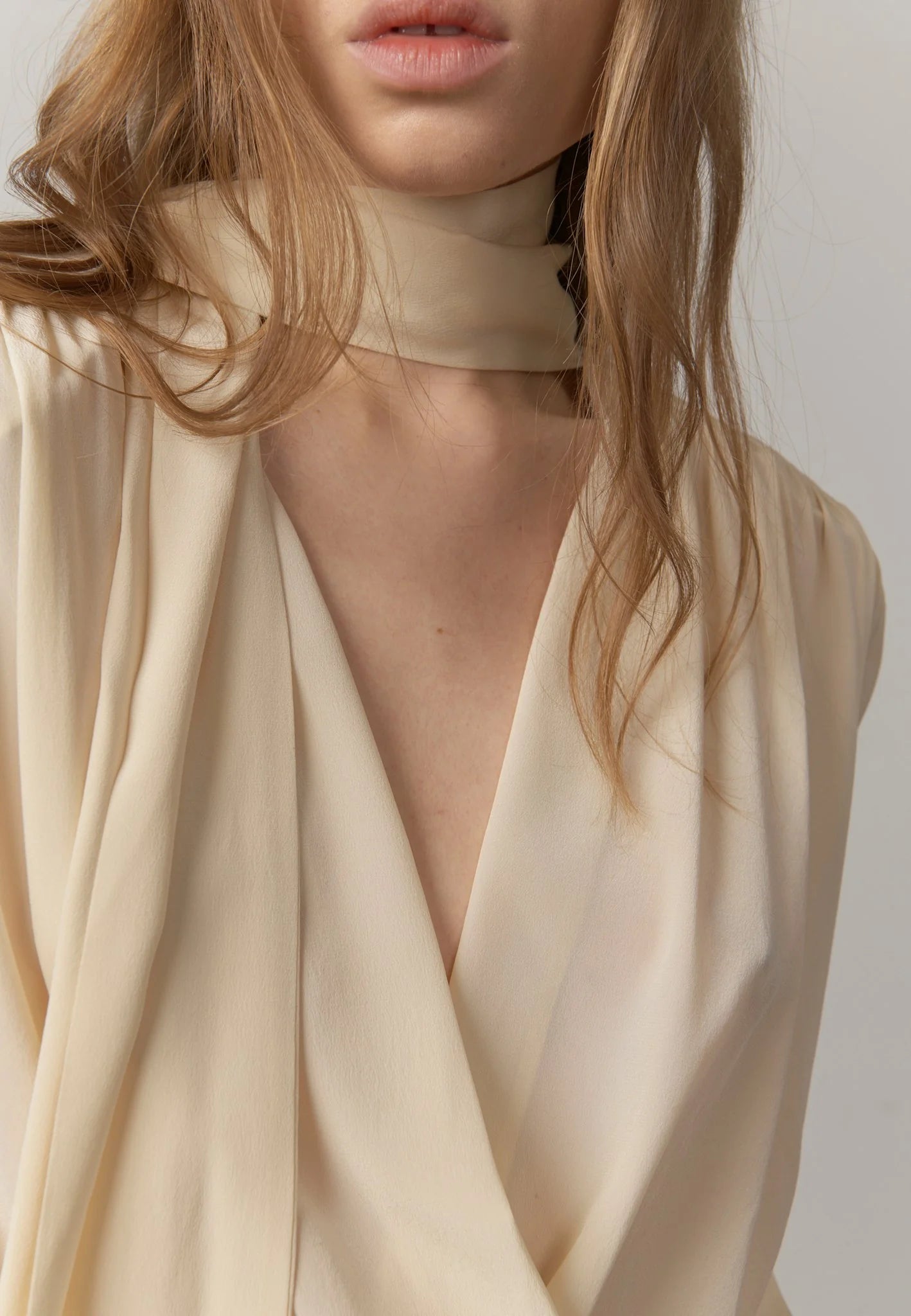 Close-up of the crossover neckline and long self-tie detail