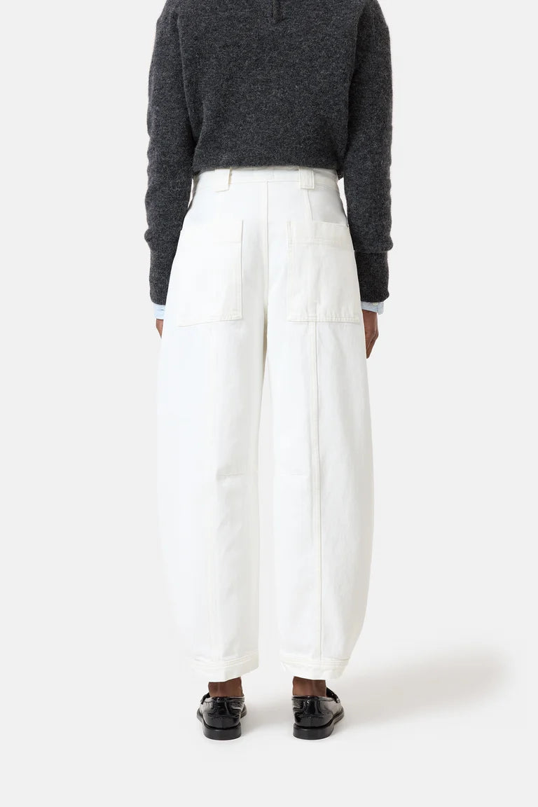 Person wearing a dark gray sweater and white pants on a white background