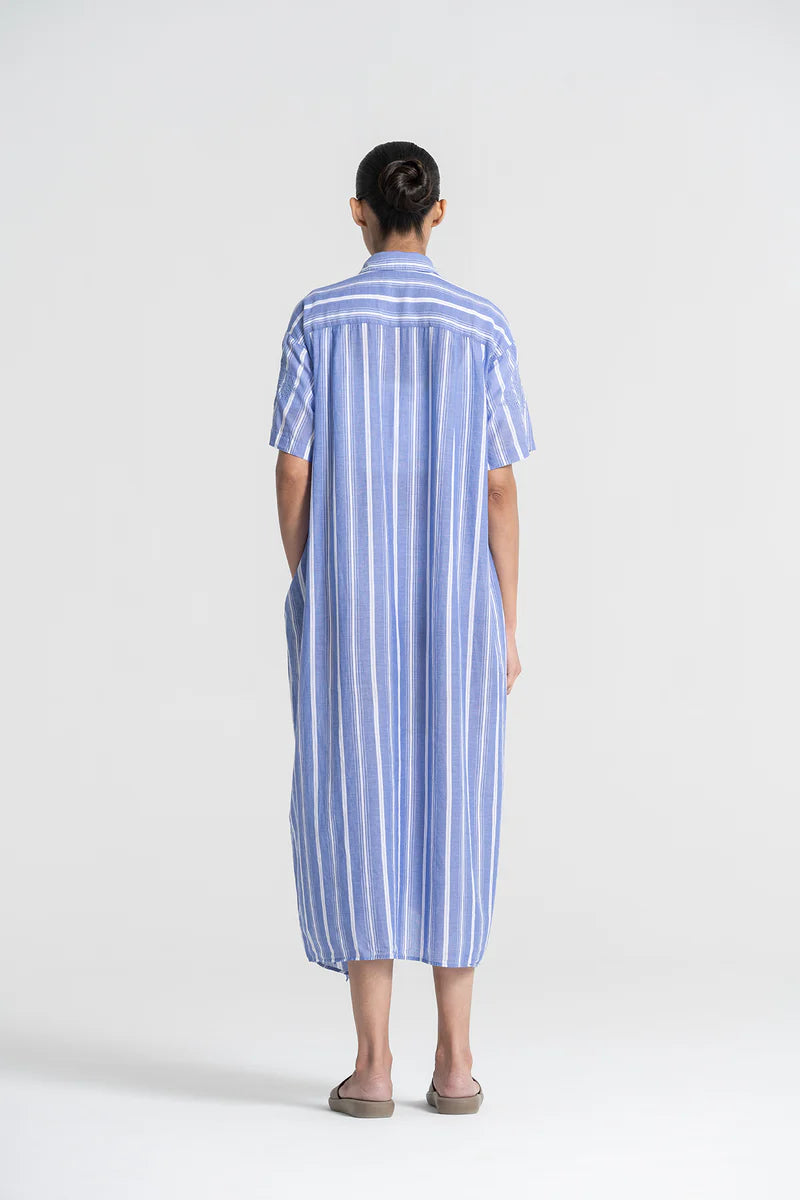 Person wearing a blue and white striped dress on a white background