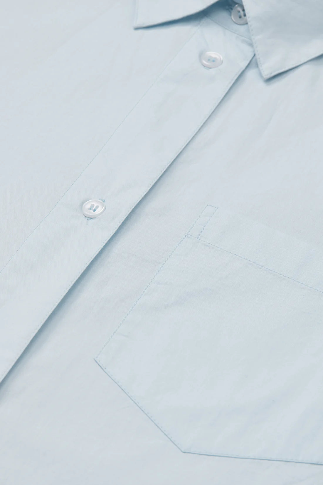 Close-up of a light blue shirt with buttons