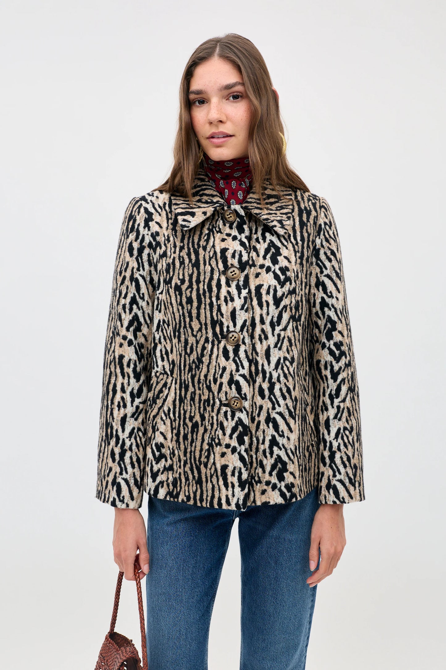 Woman wearing a leopard print coat on a white background
