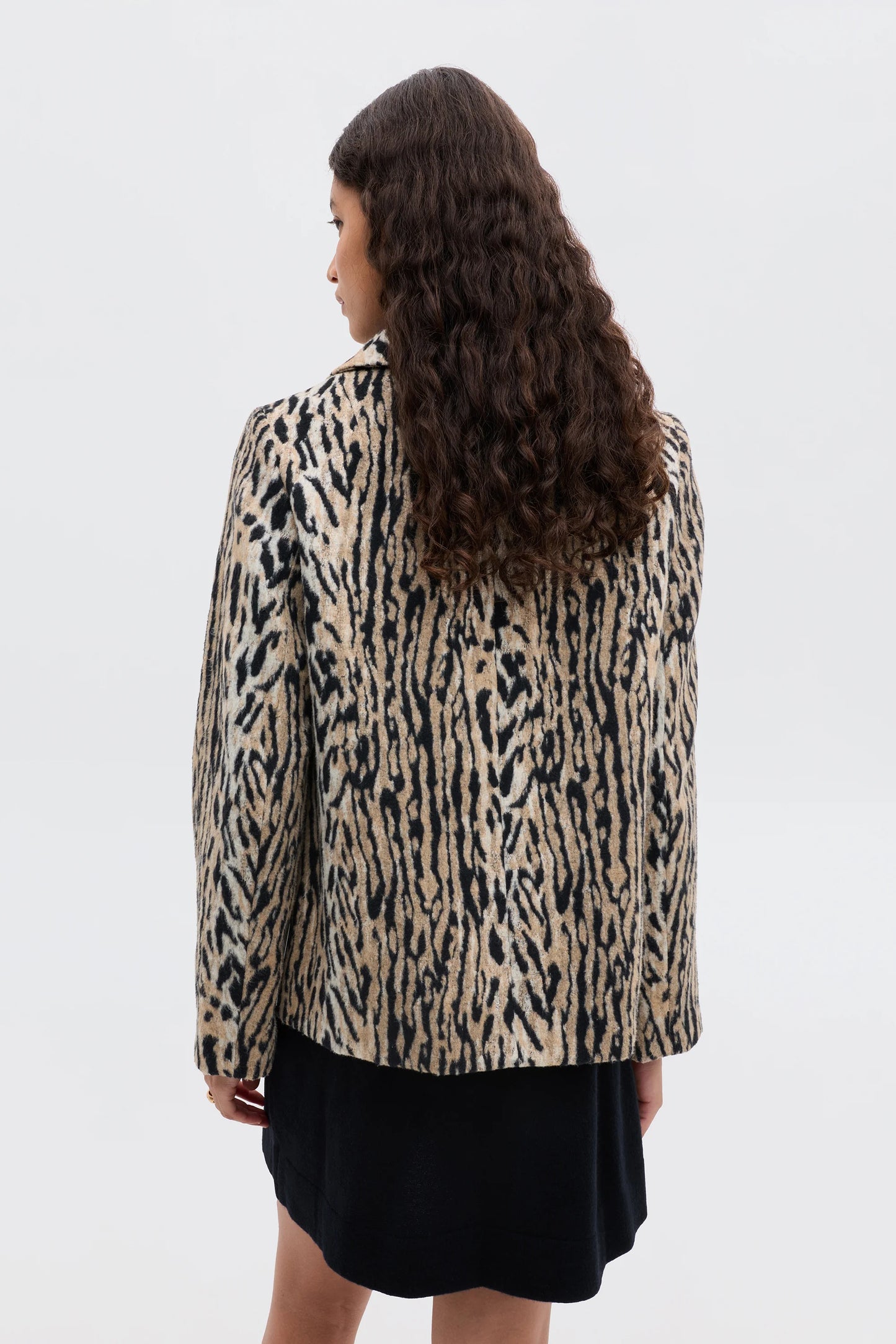Person wearing a leopard print jacket on a white background