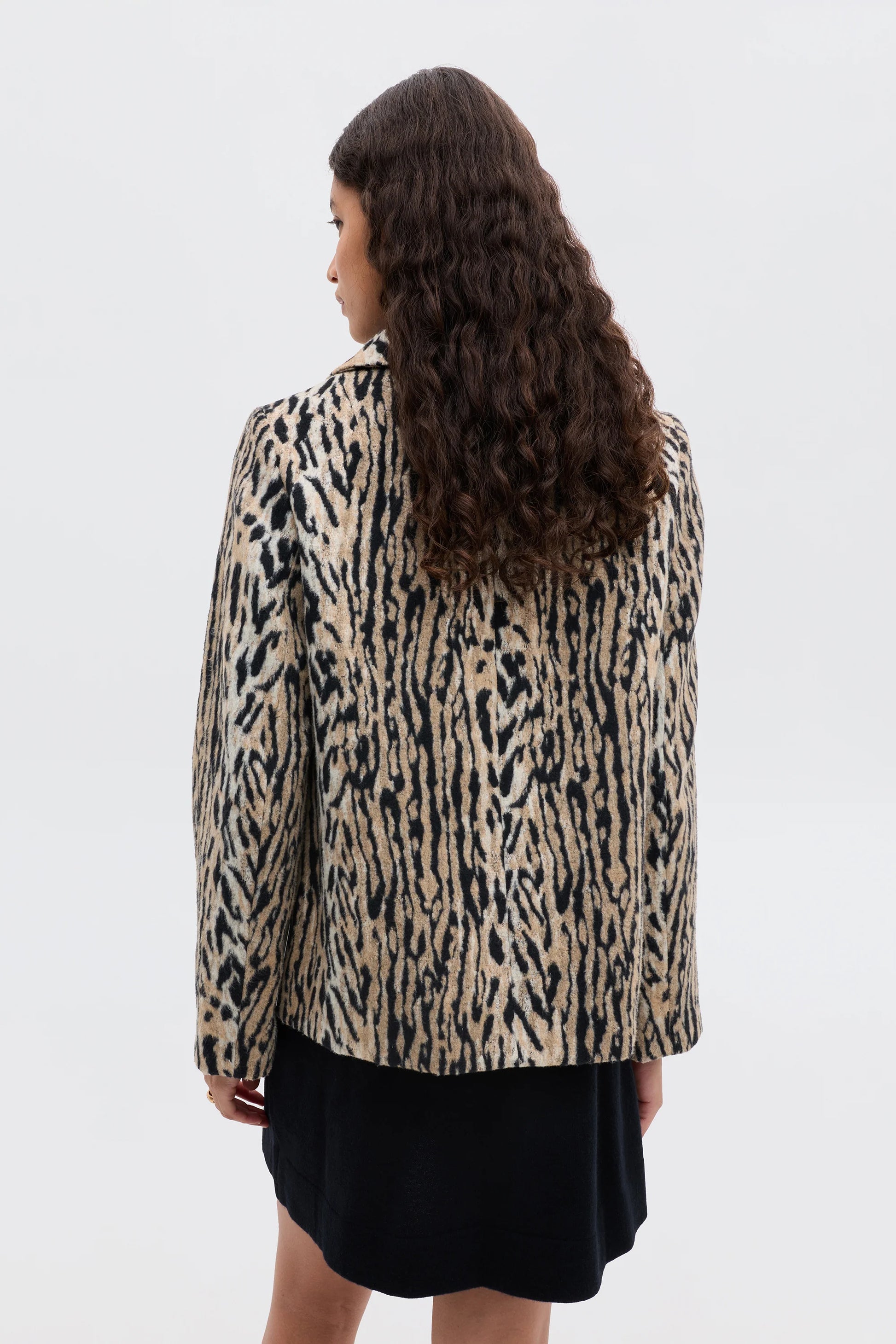 Person wearing a leopard print jacket on a white background