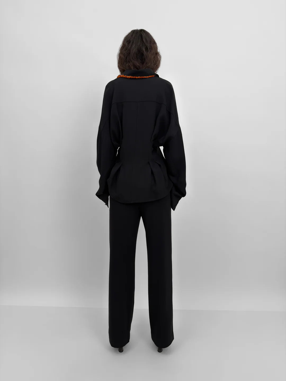 Person wearing a black suit on a white background