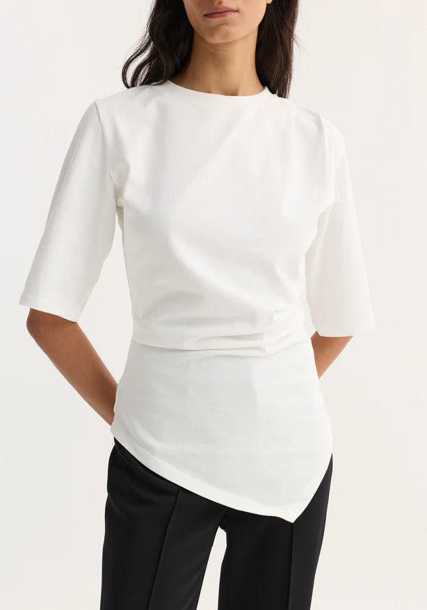 Woman wearing a white blouse with black pants on a white background