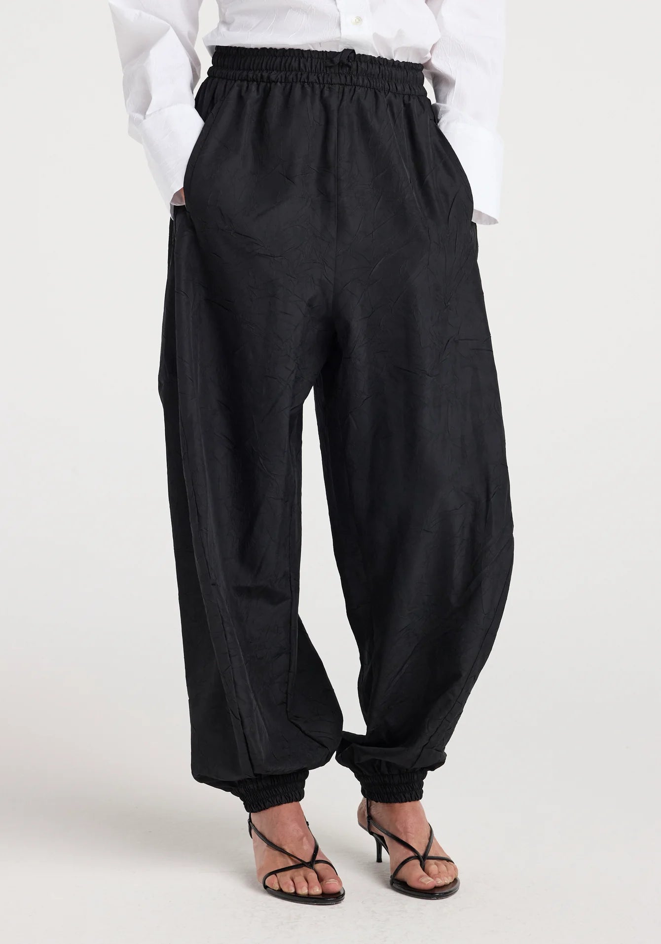 Person wearing black wide-leg pants on a white background