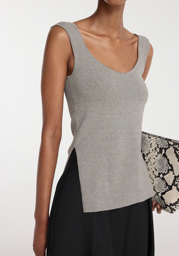 Woman wearing a gray sleeveless top with a plain background