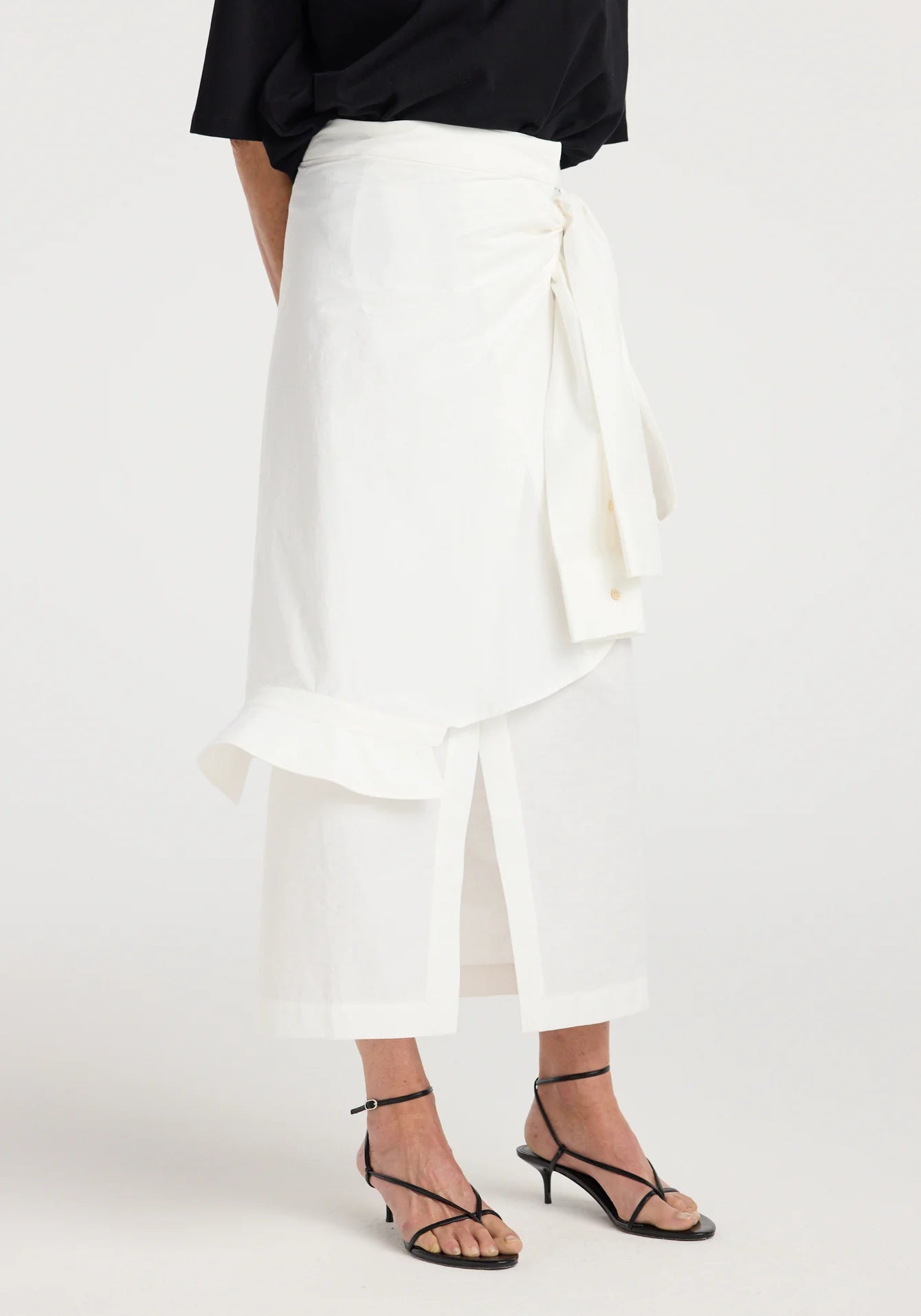 White wrap skirt worn by a person on a white background
