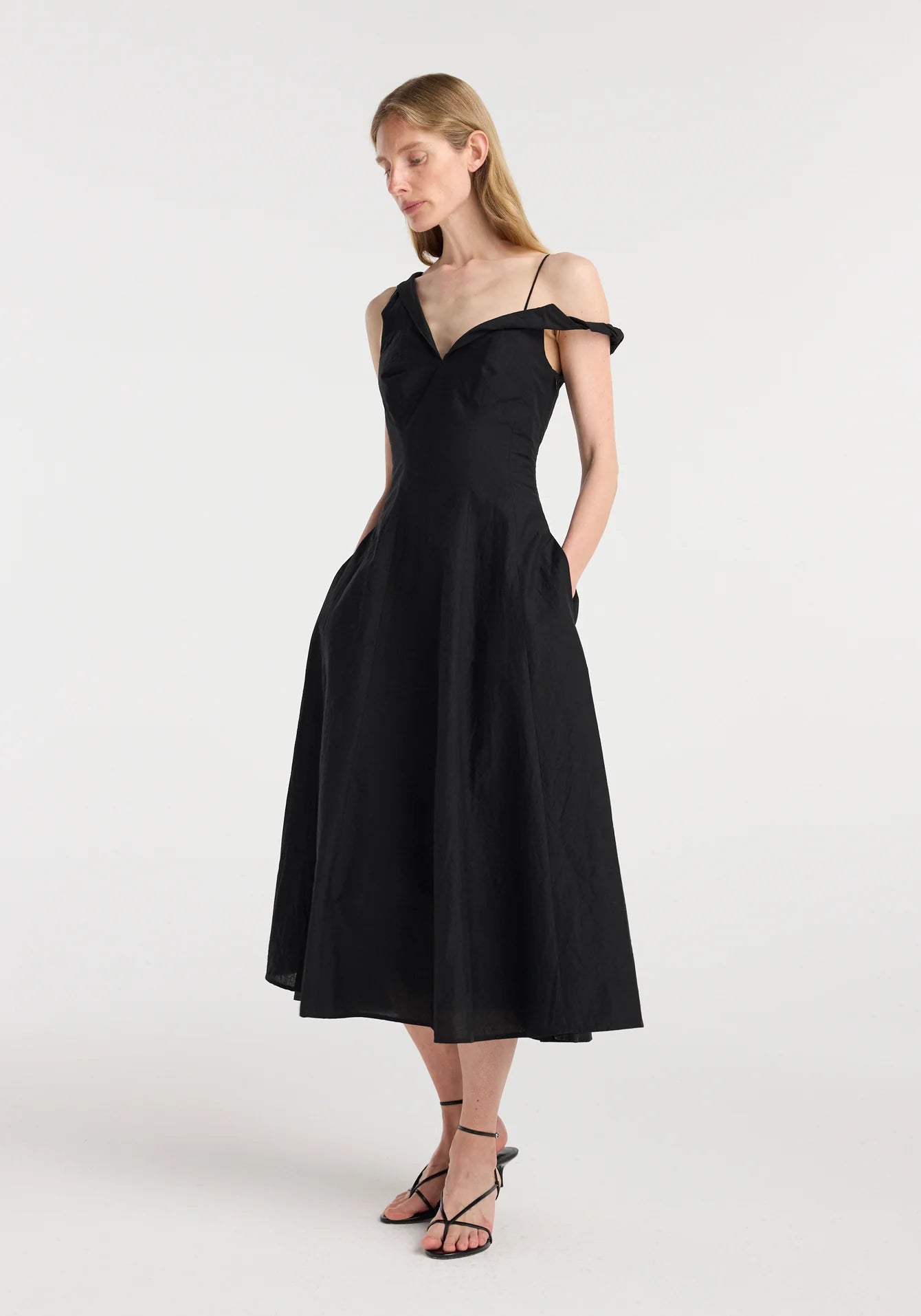 Side view highlighting the asymmetric neckline, open shoulder detail and fluid A line silhouette.