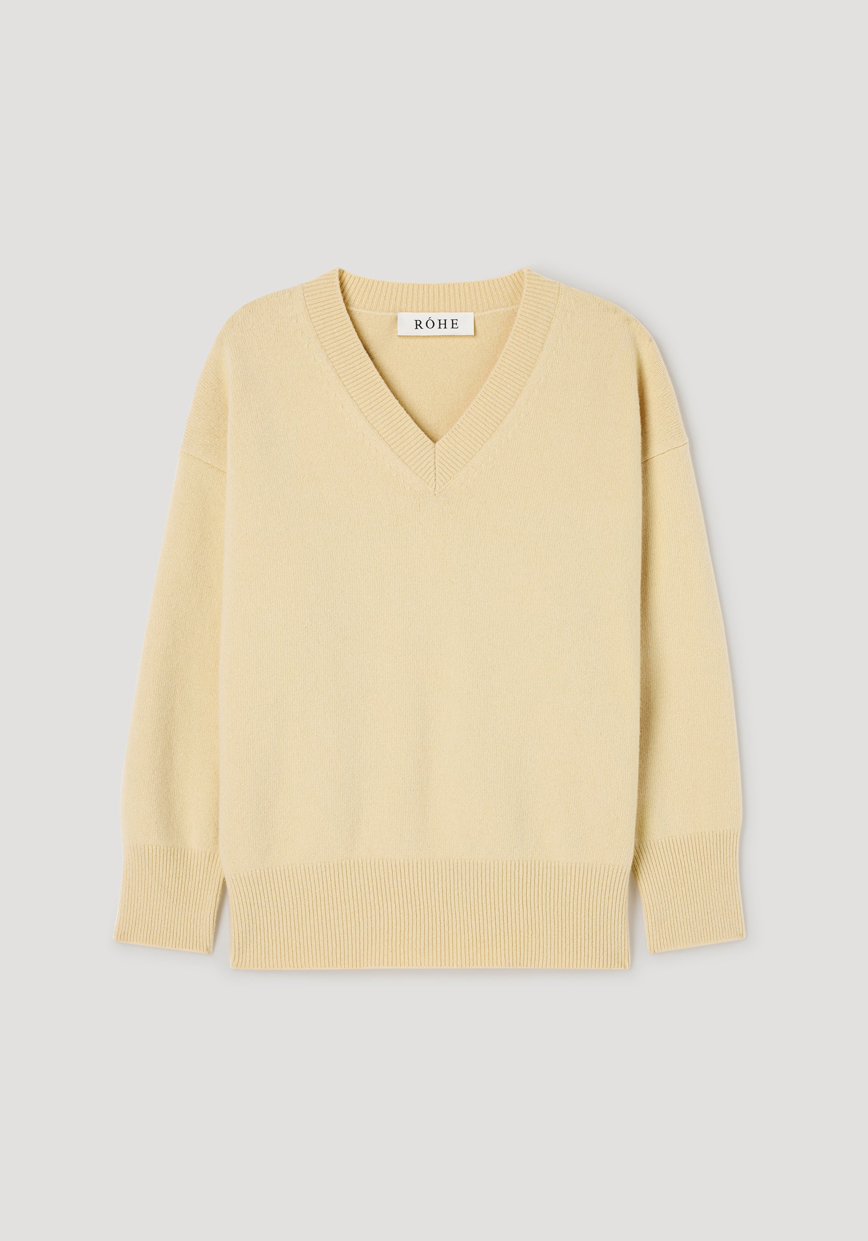 A pale yellow V-neck knit sweater with ribbed trim at the collar, cuffs, and hem, displayed flat against a light gray background. The brand name 'NOWE' is visible on the inner neck label.