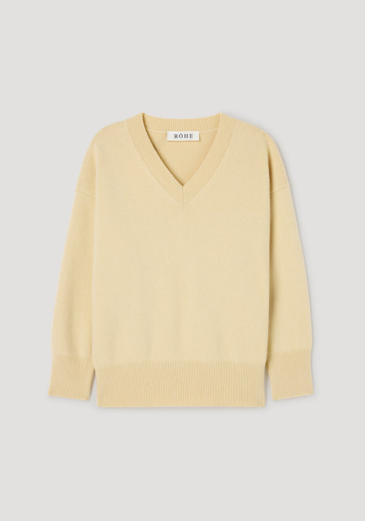 A pale yellow V-neck knit sweater with ribbed trim at the collar, cuffs, and hem, displayed flat against a light gray background. The brand name 'NOWE' is visible on the inner neck label.
