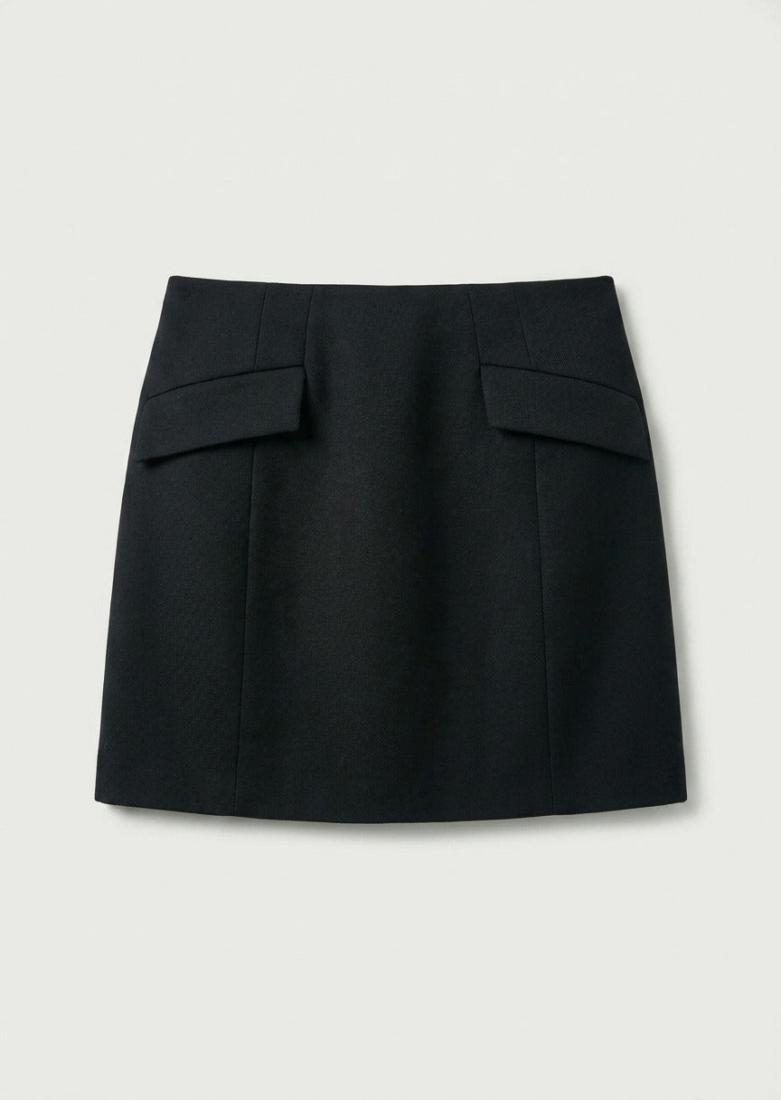 A black A-line mini skirt with structured flap pockets on the front, displayed flat against a light gray background.