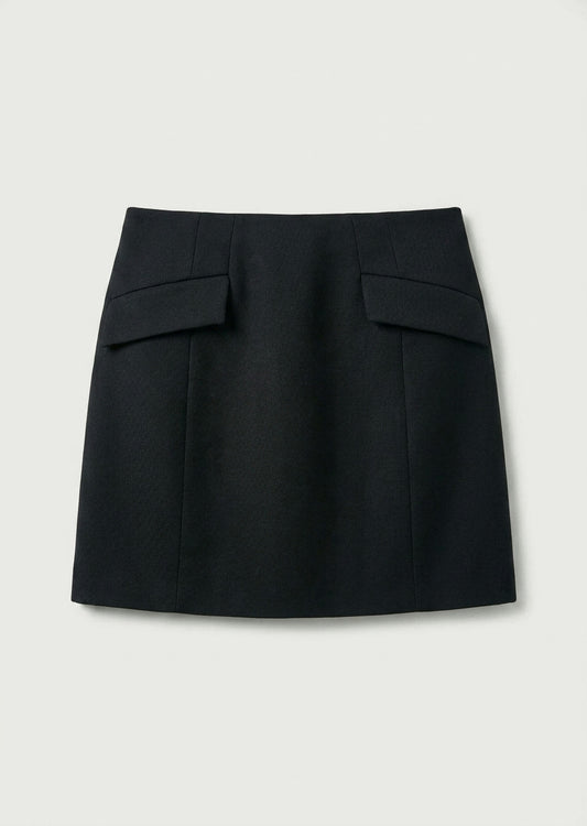 A black A-line mini skirt with structured flap pockets on the front, displayed flat against a light gray background.
