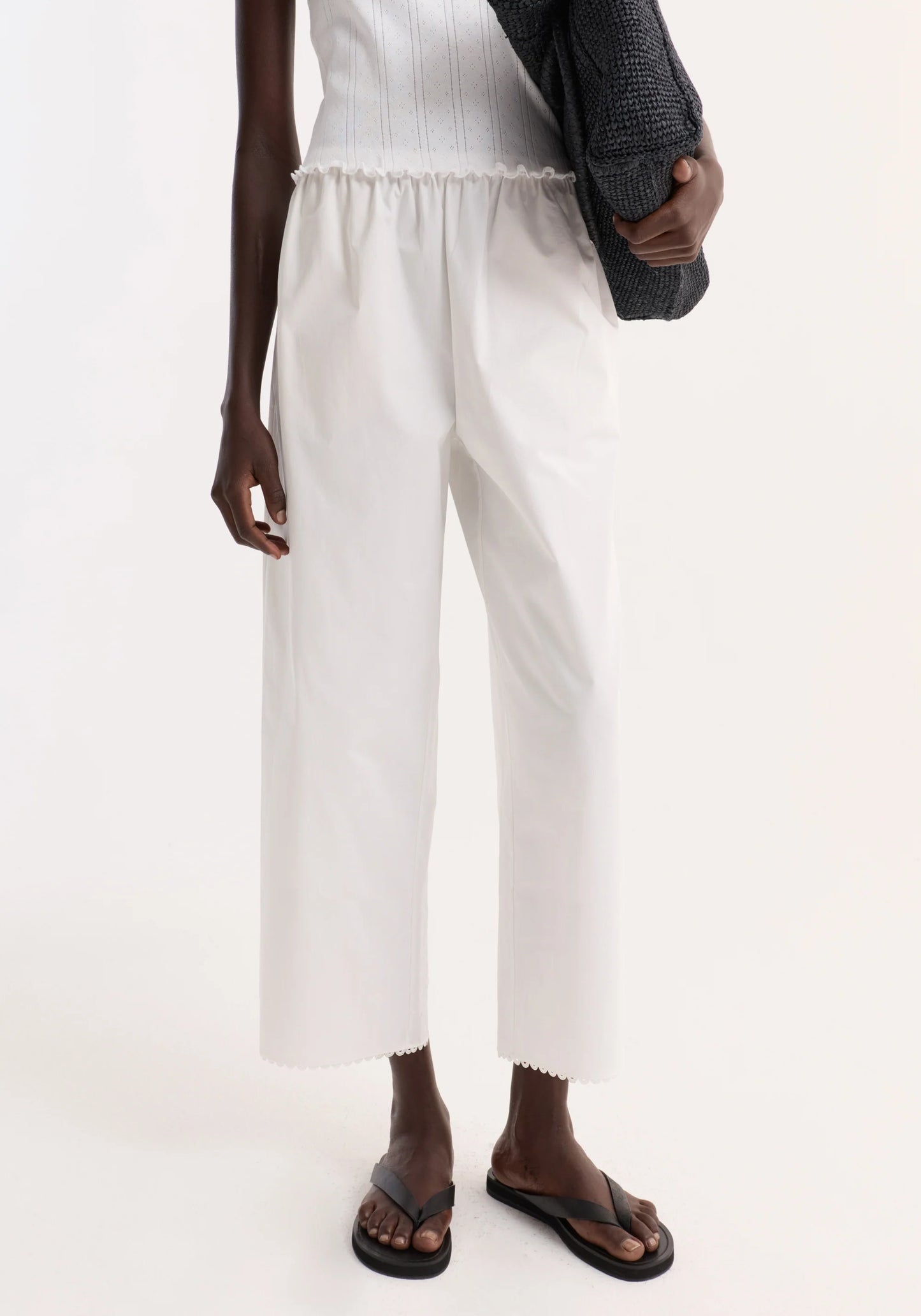 Person wearing white pants on a plain background
