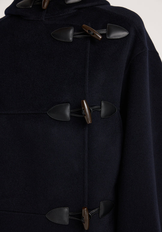 Close-up of a dark coat with large buttons on a white background