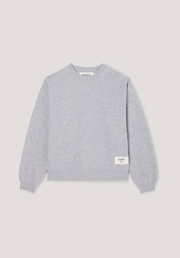 Gray sweater with brand logo on a light gray background