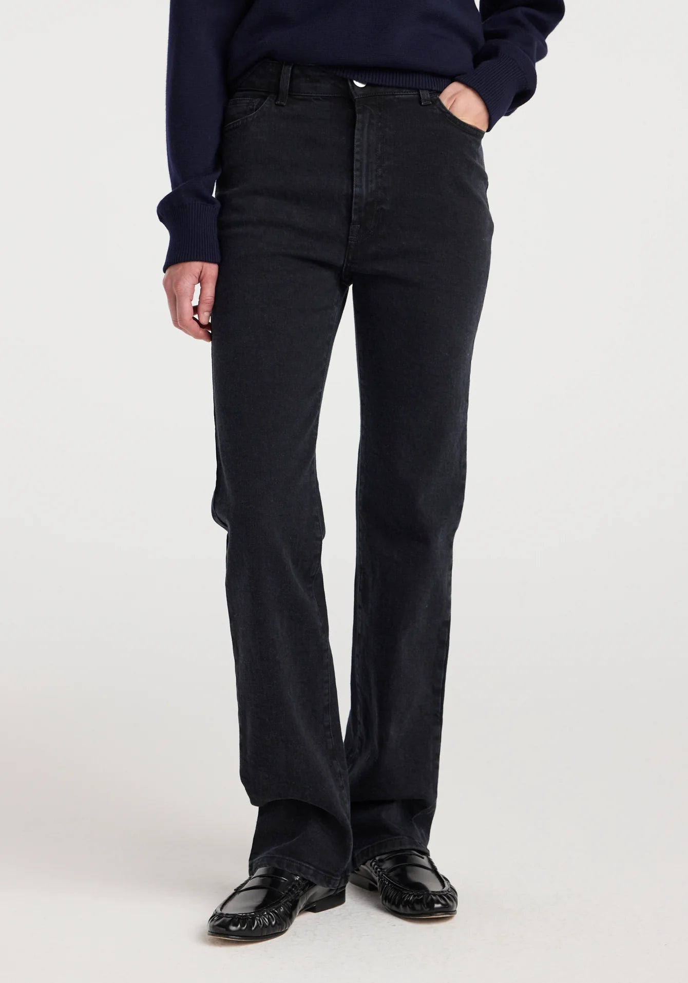 Person wearing black pants and a dark shirt on a white background