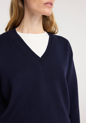 Navy blue sweater worn by a person on a white background