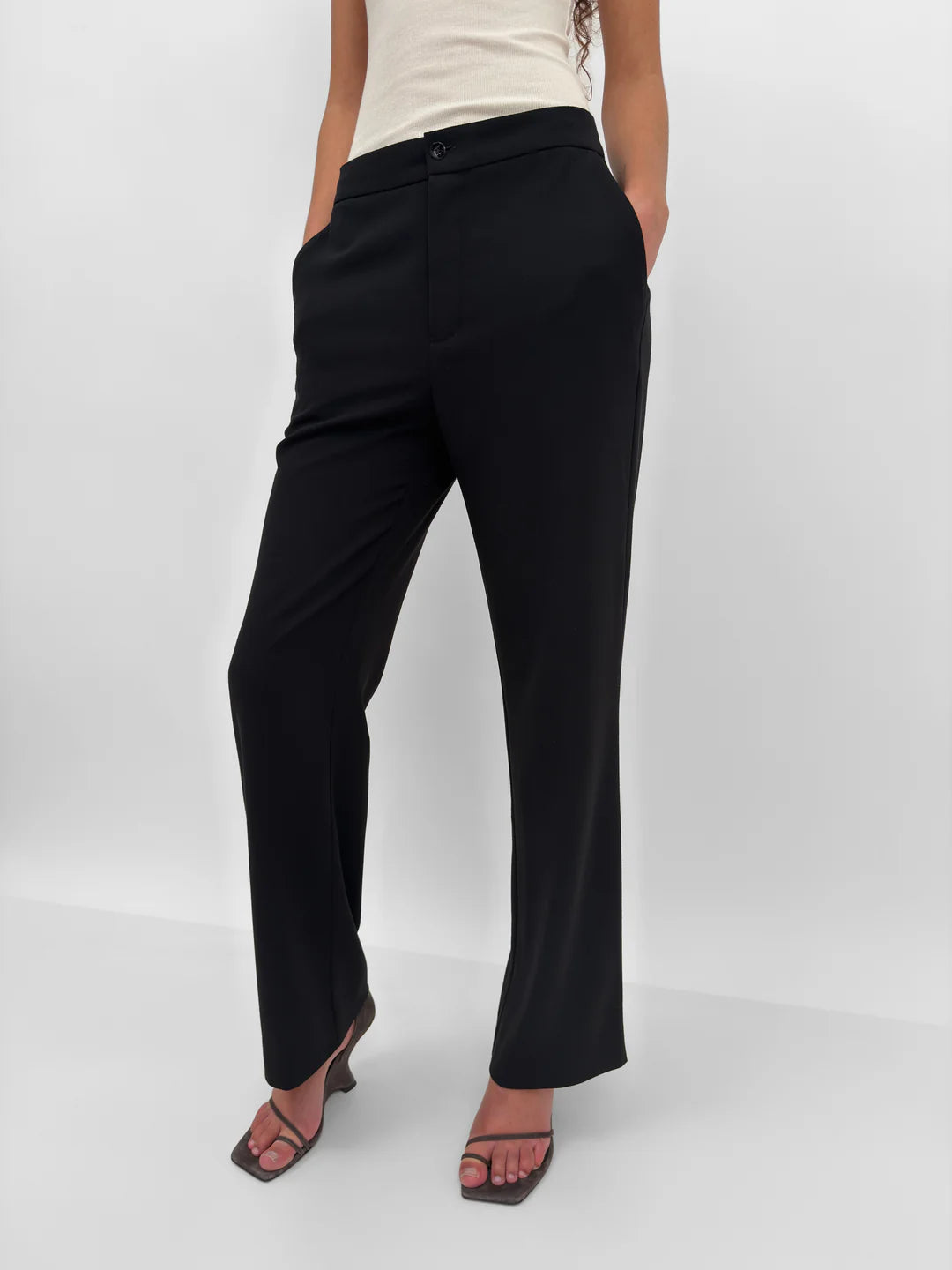 Person wearing black pants on a white background