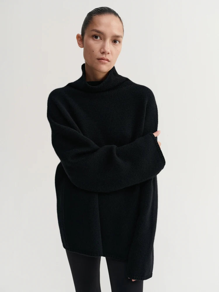 Person wearing a black oversized sweater on a white background