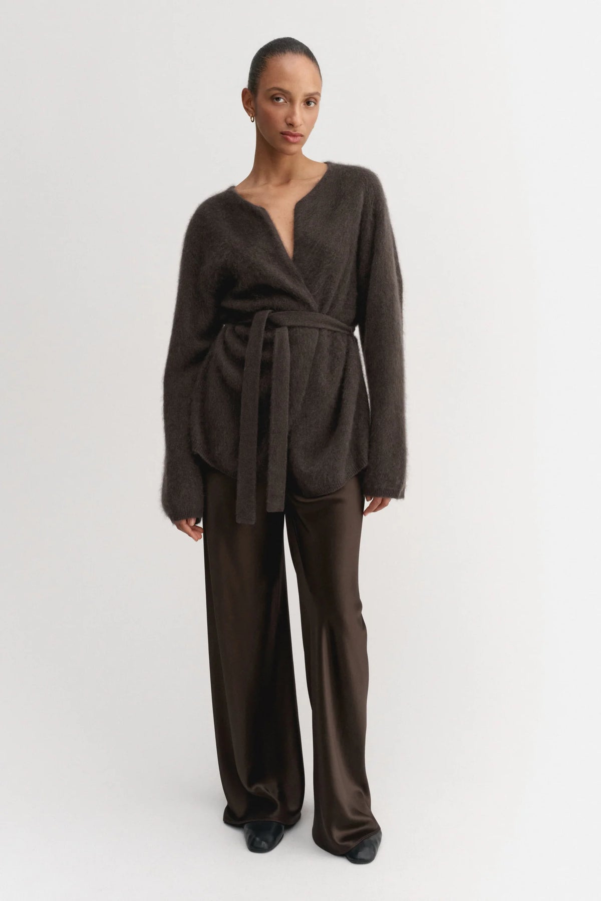 Woman wearing a brown jumpsuit on a white background