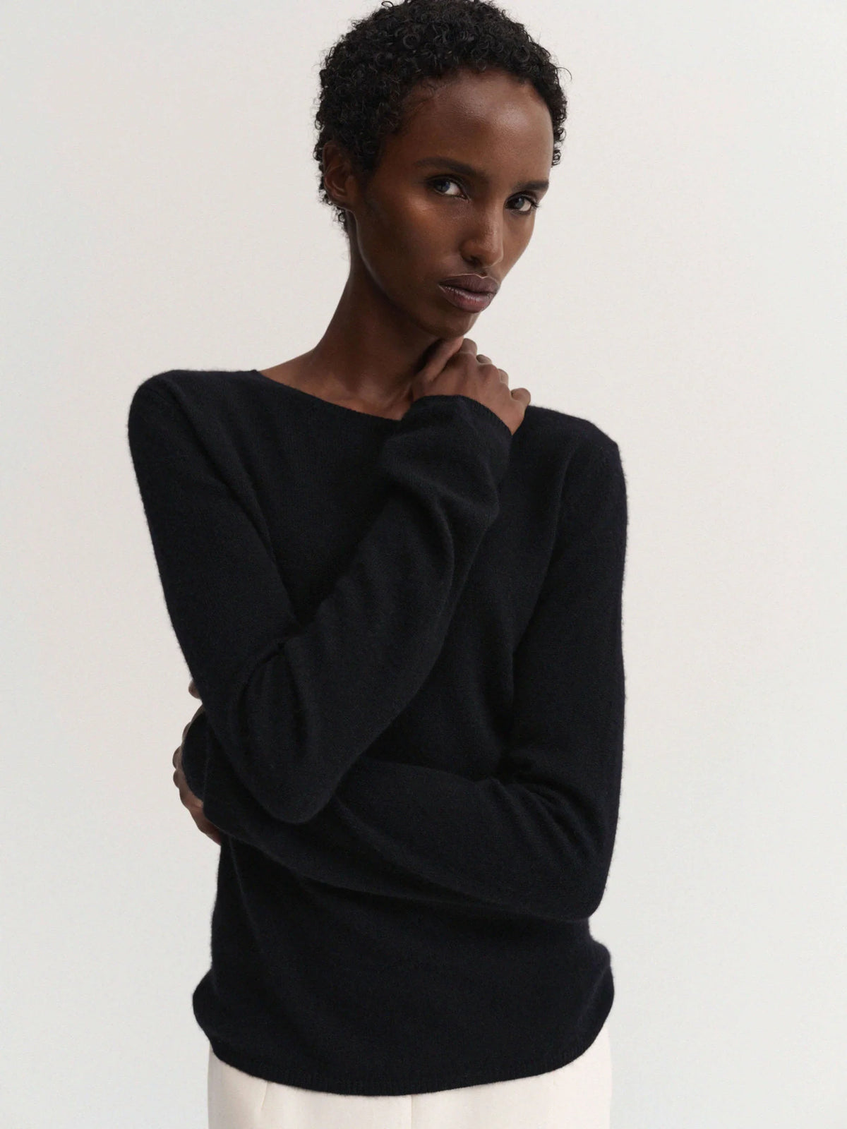 Woman wearing a black sweater against a plain background