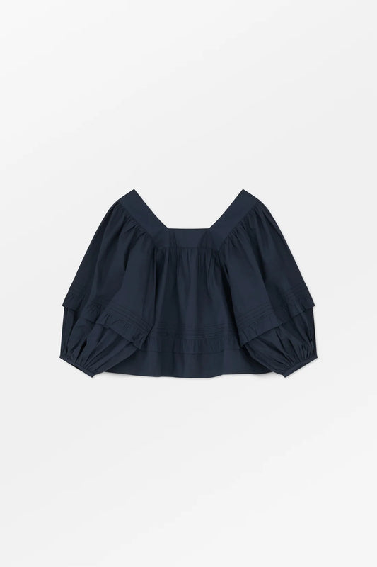 Navy blue top with balloon sleeves on a light gray background