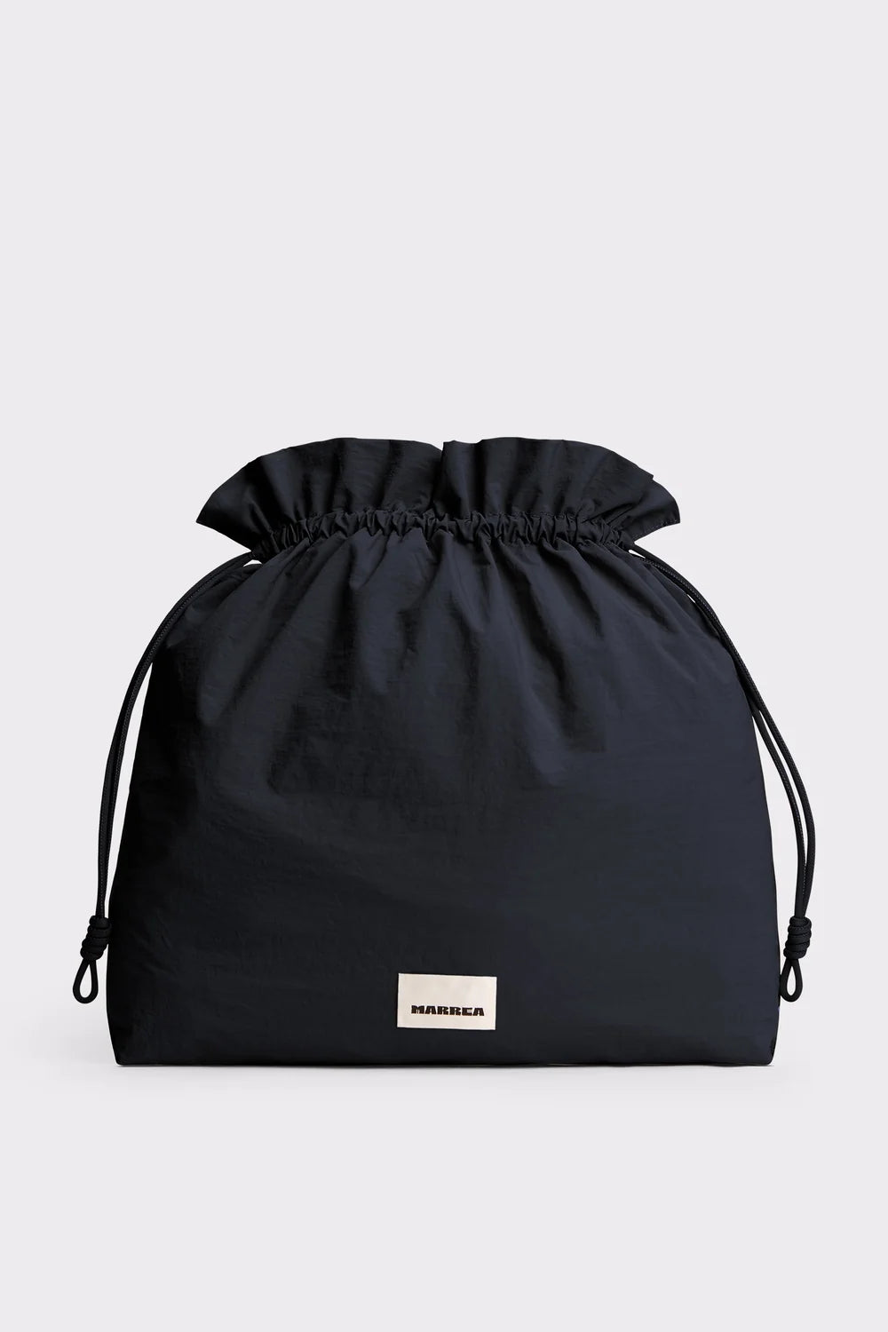 A black drawstring pouch bag with a small white rectangular brand label reading 'MURMIL' on the front, photographed against a light gray background.