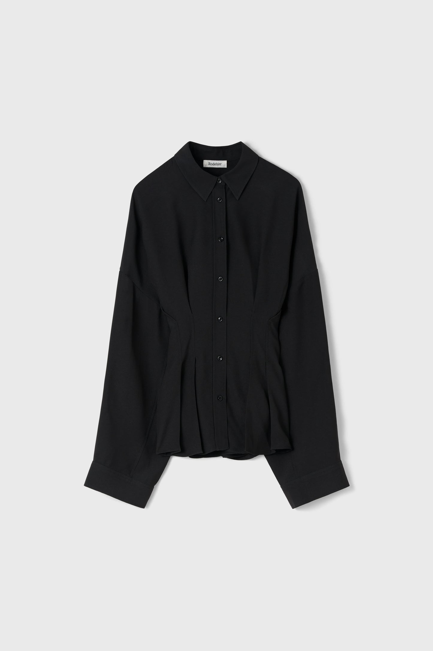 A black long-sleeve button-up shirt with a pointed collar and a subtle peplum-like gathered waist detail, displayed flat against a light gray background.