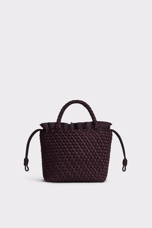 A dark plum purple woven leather handbag with a top handle, ruffled trim, and drawstring details, shown against a light gray background.