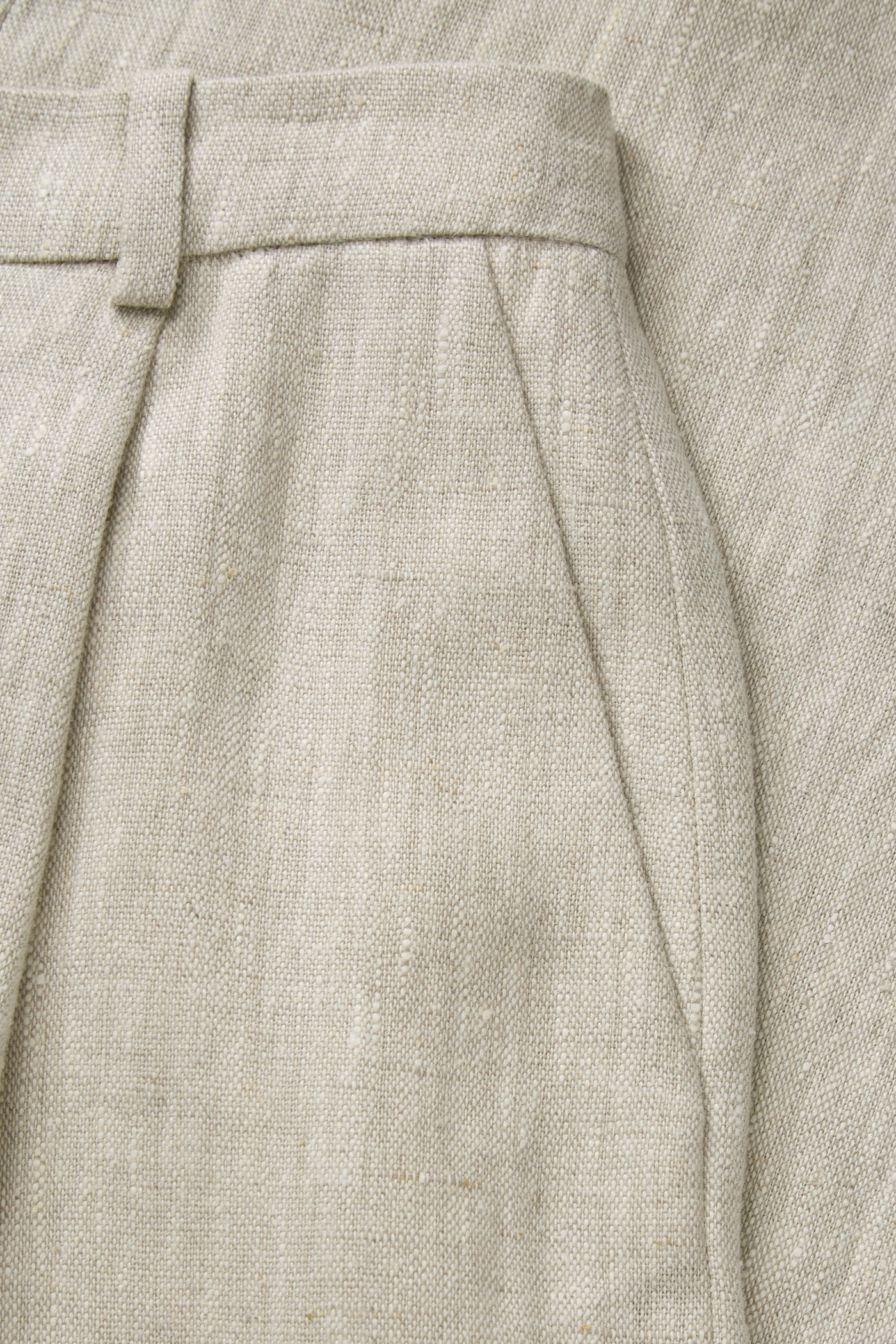 Close-up of beige textured fabric with a belt