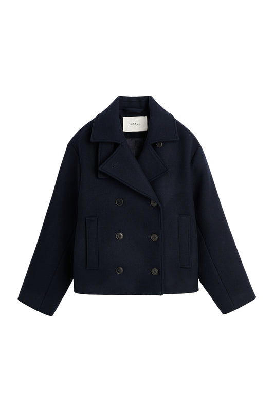 A dark navy blue cropped double-breasted coat with wide lapels and dark buttons, displayed flat against a solid white background.