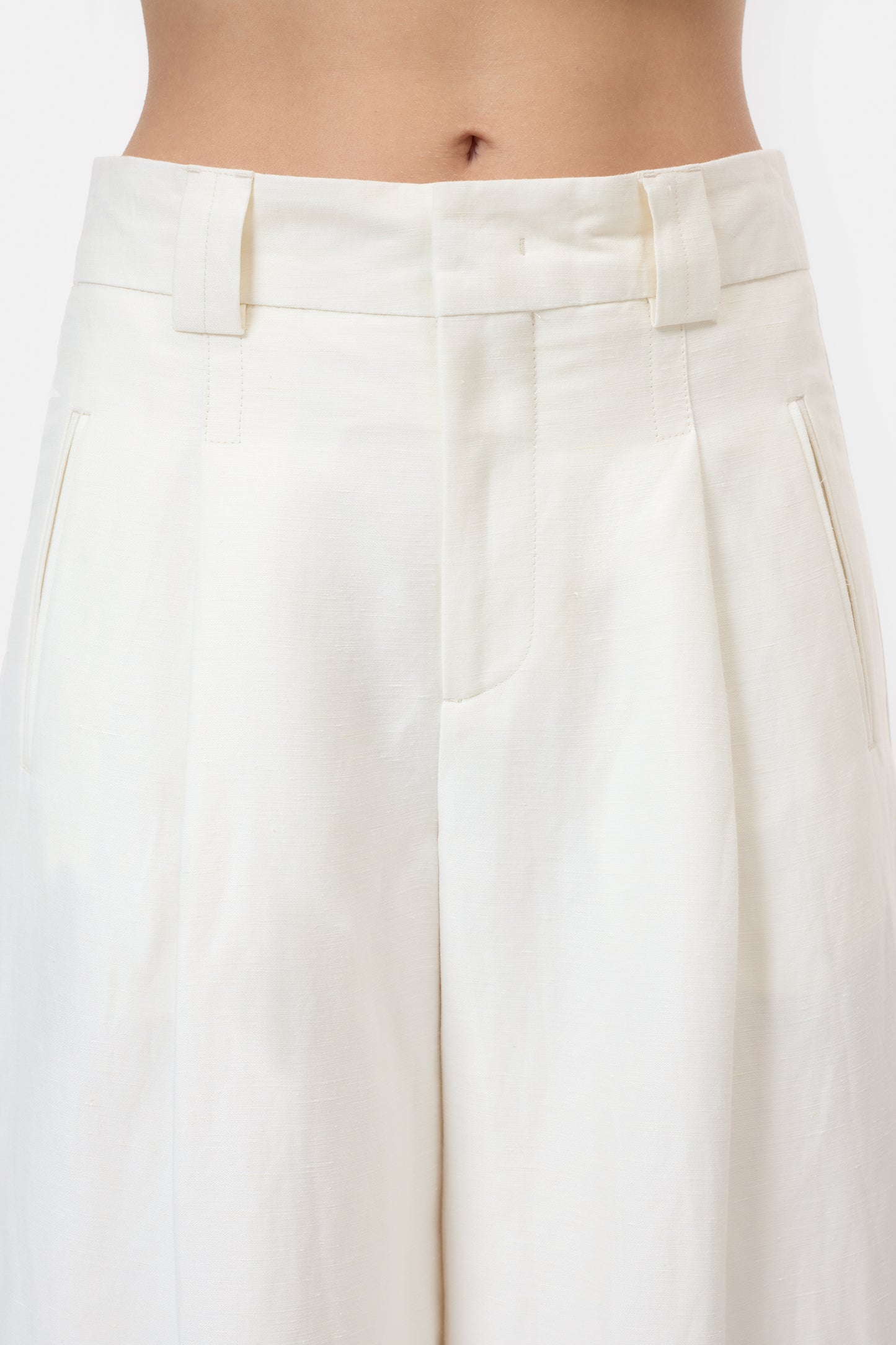 White pleated skirt worn by a person on a white background