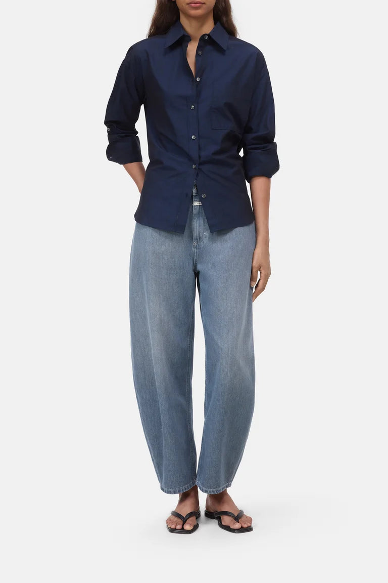 Person wearing a navy shirt and light blue jeans on a white background