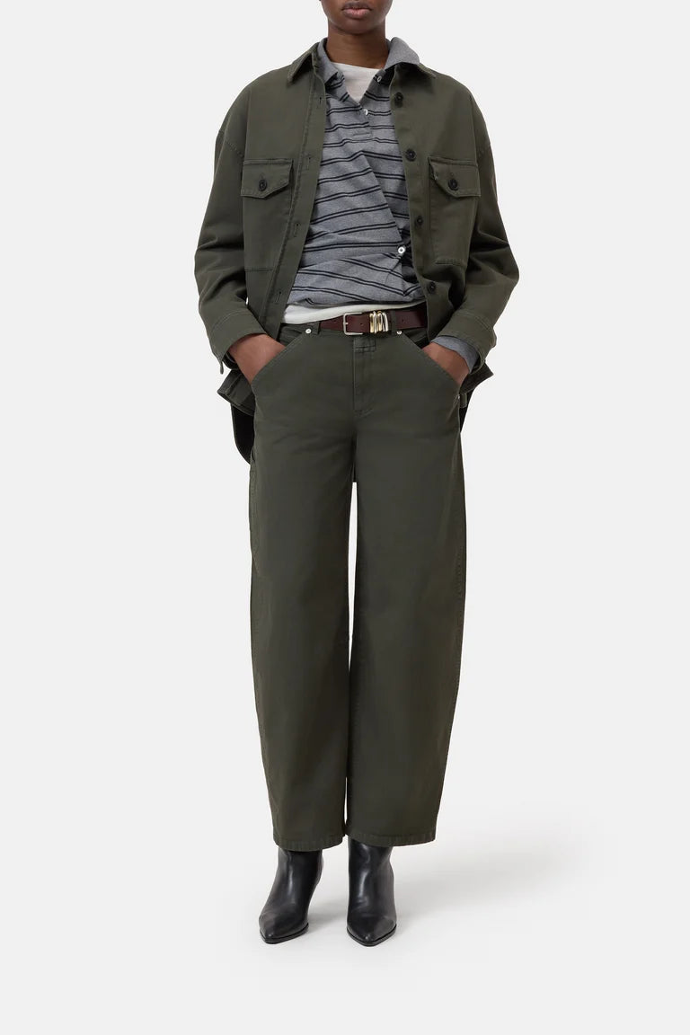 Person wearing a green jacket, striped shirt, and wide-leg pants on a white background