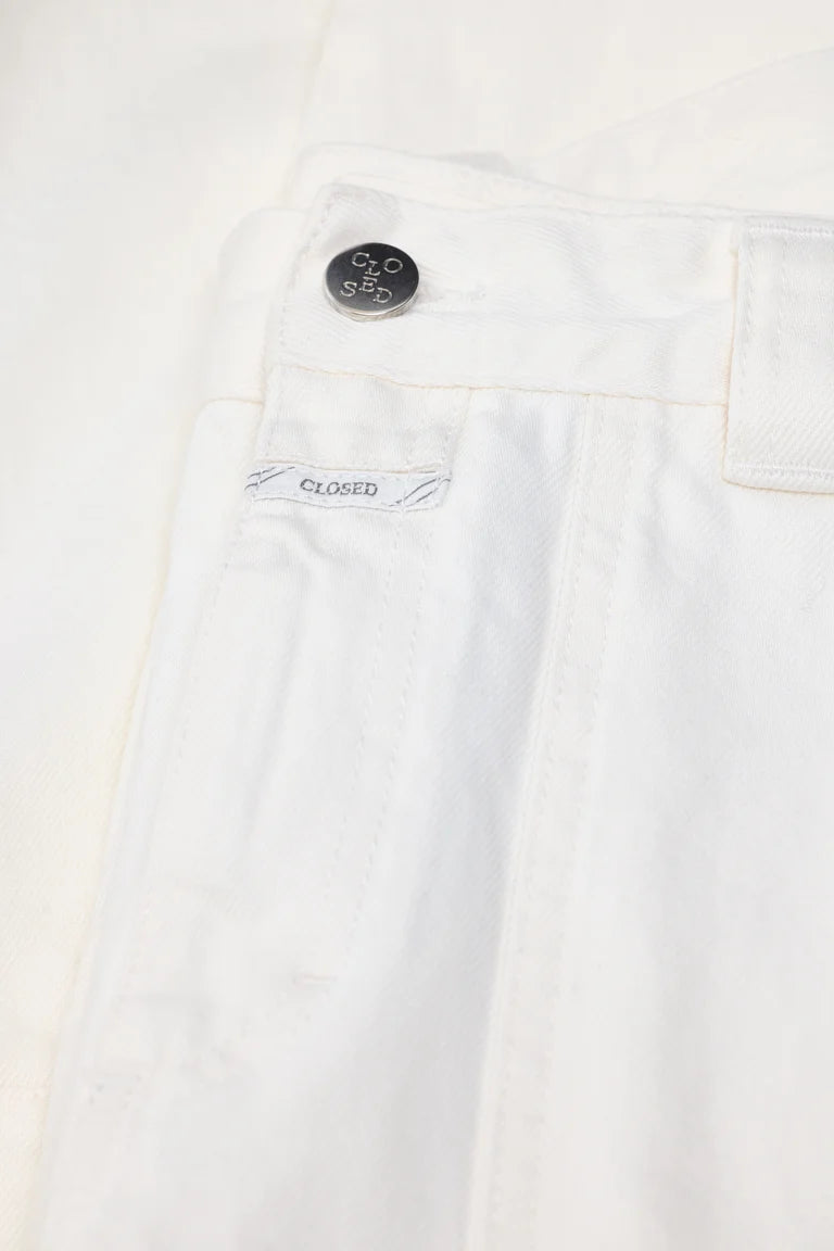 Close-up of white pants with a brand label on a white background