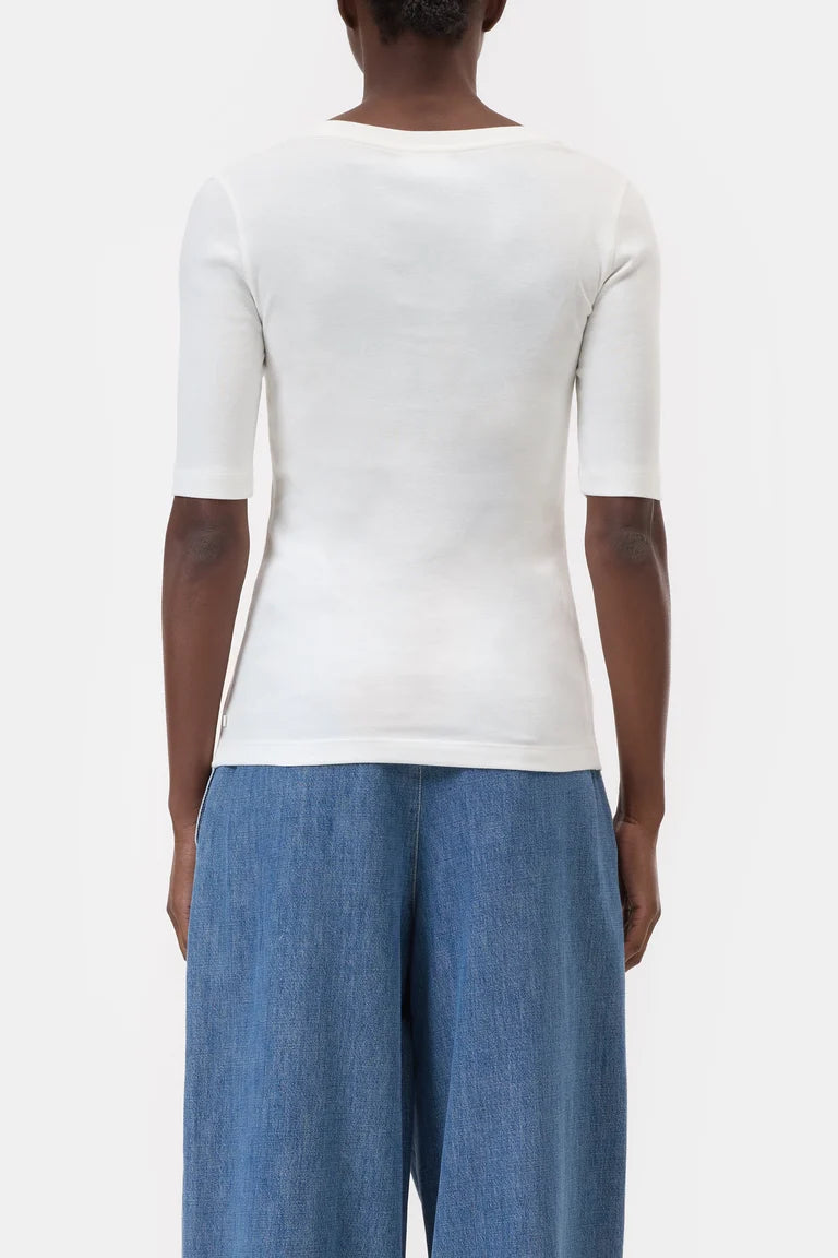 Person wearing a white top and blue pants on a plain background