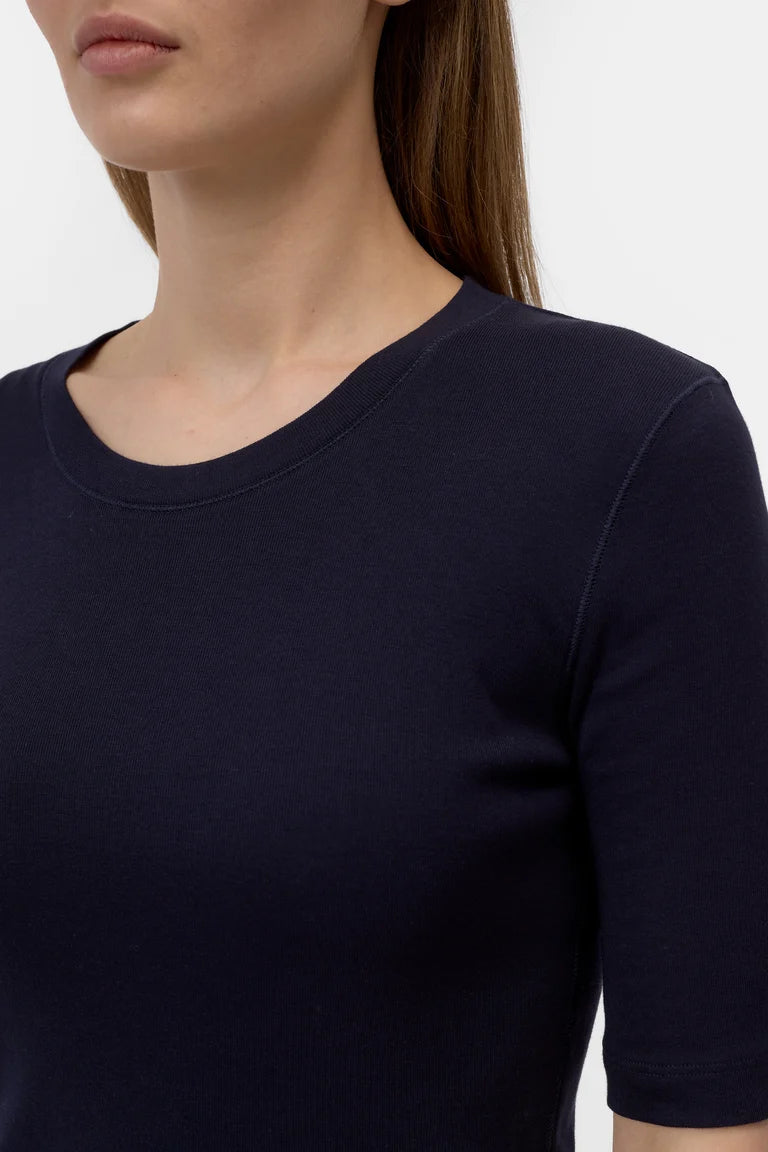 Navy blue t-shirt worn by a person on a white background