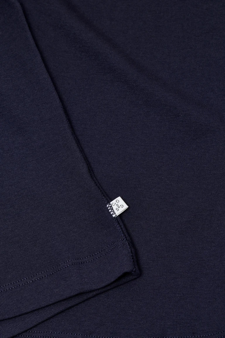 Close-up of a navy blue garment with a brand label on a dark background