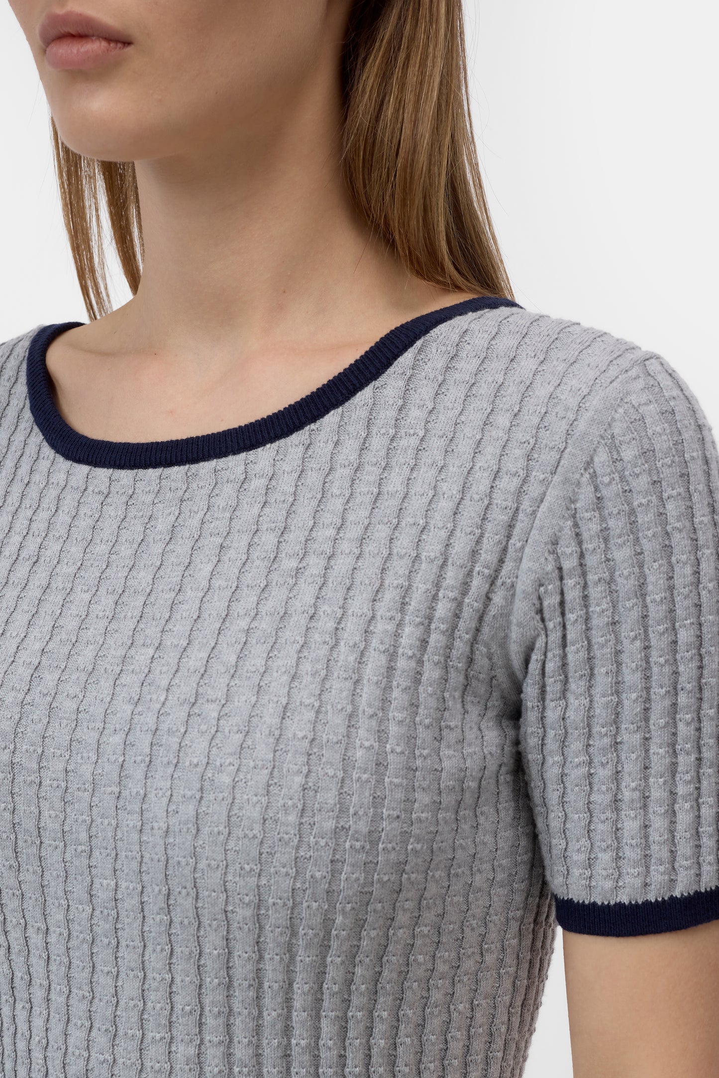 Gray ribbed sweater with navy trim on a plain background