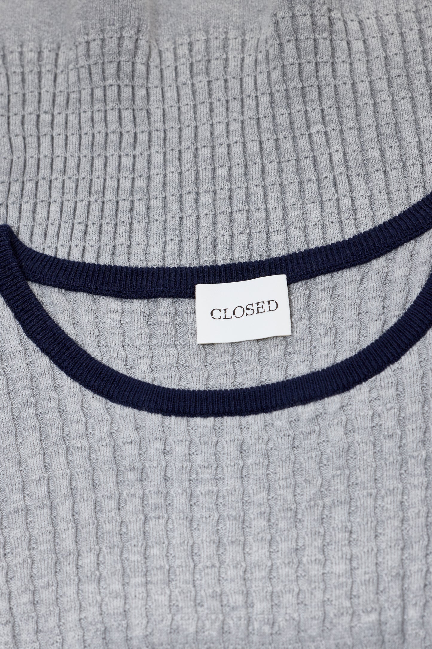 Gray textured sweater with navy ribbed trim and a 'CLOSED' label.