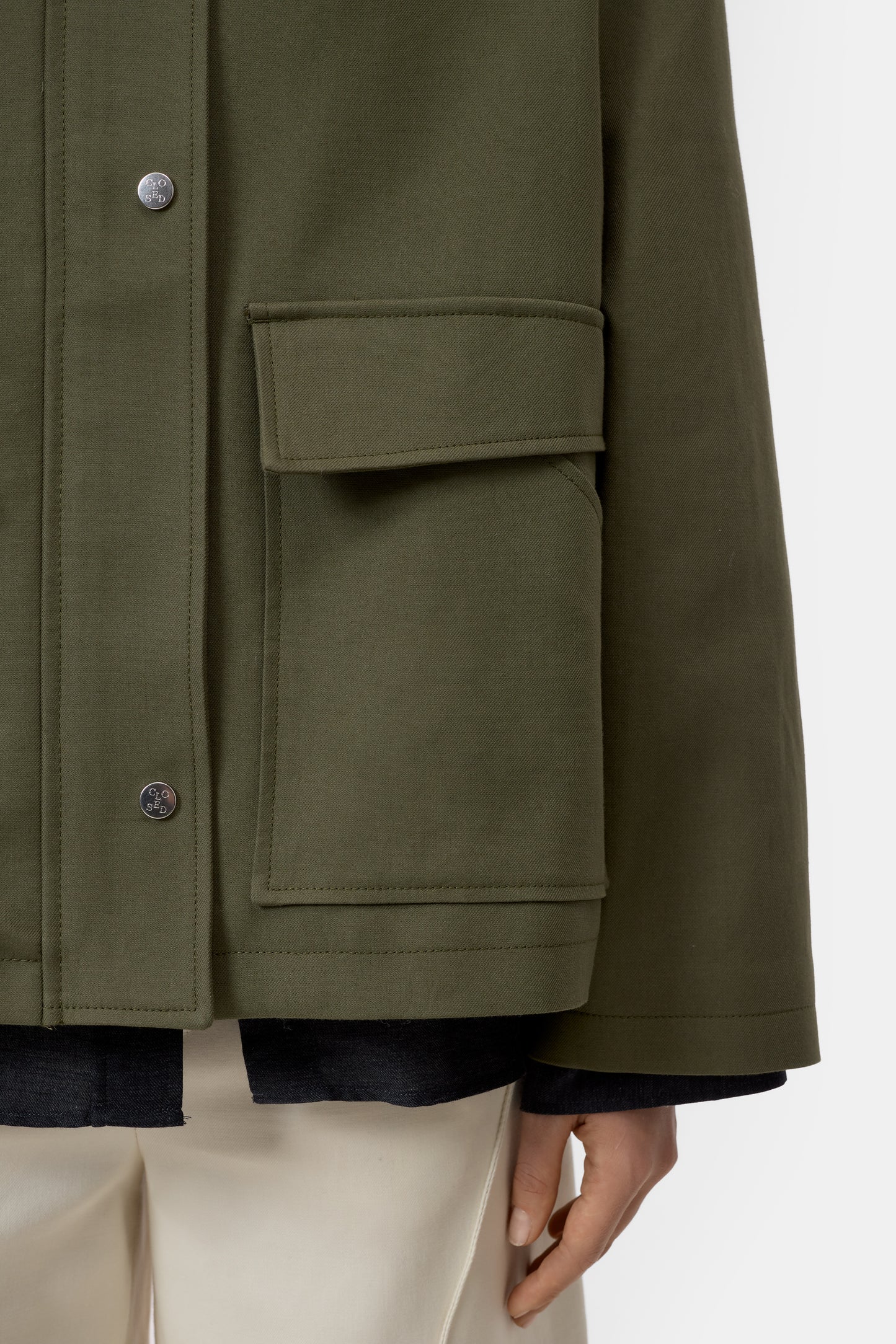 Green jacket with a pocket and buttons on a white background