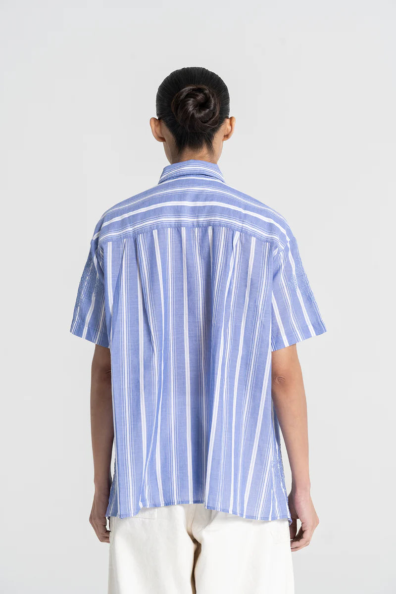 Person wearing a blue and white striped shirt on a white background