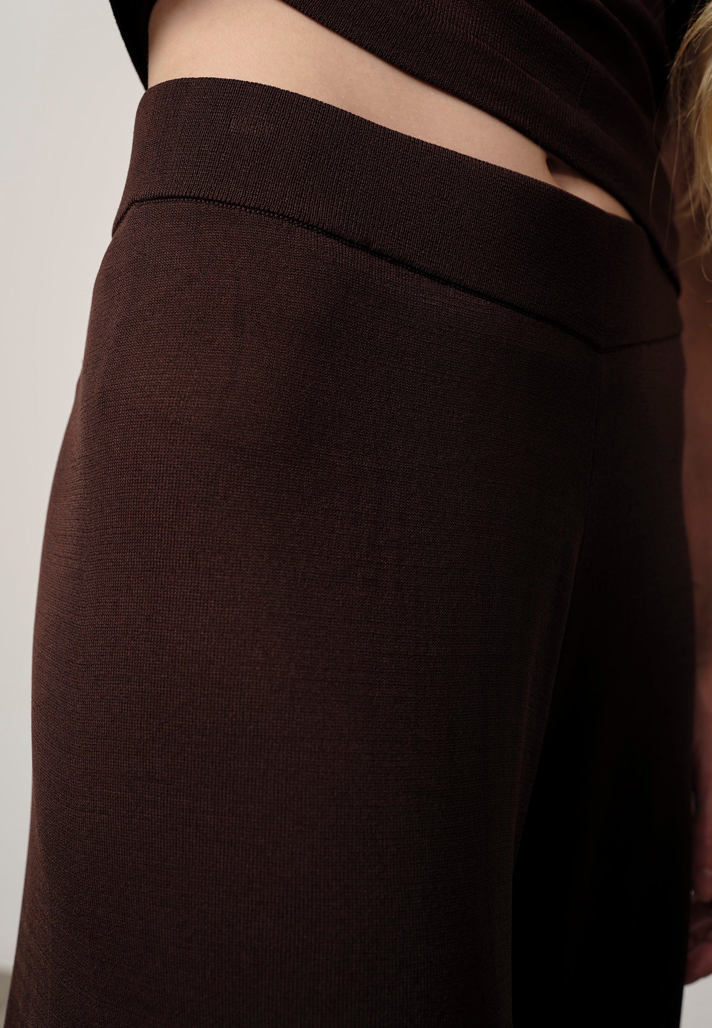 Brown pants with a visible brand label on a plain background