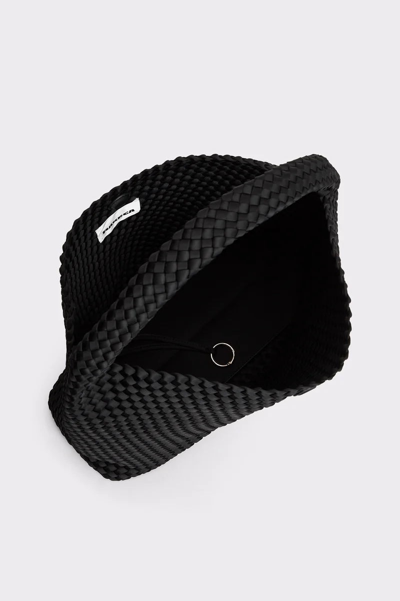 A black woven bucket bag with a textured basketweave pattern, shown from an overhead angle on a light gray background.