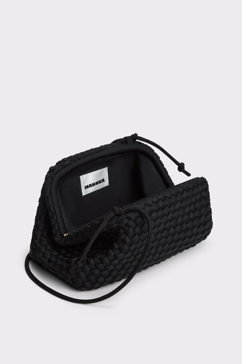 A black woven leather pouch with a drawstring closure, shown open to reveal its black interior and a white interior label that reads 'BARBER'.