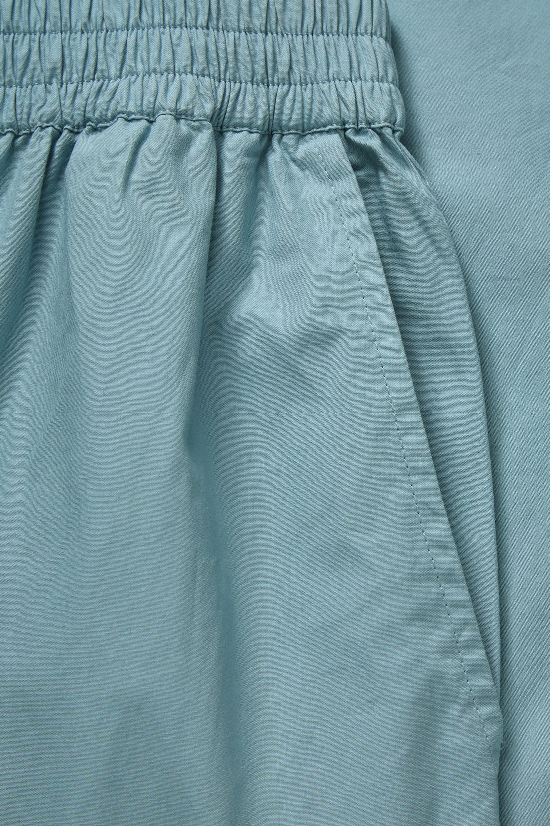 Close-up of teal pants with an elastic waistband