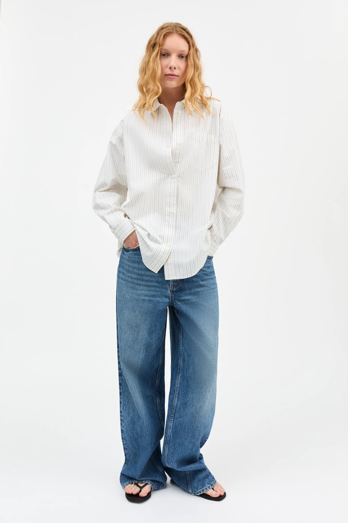Woman wearing a white shirt and blue jeans on a white background