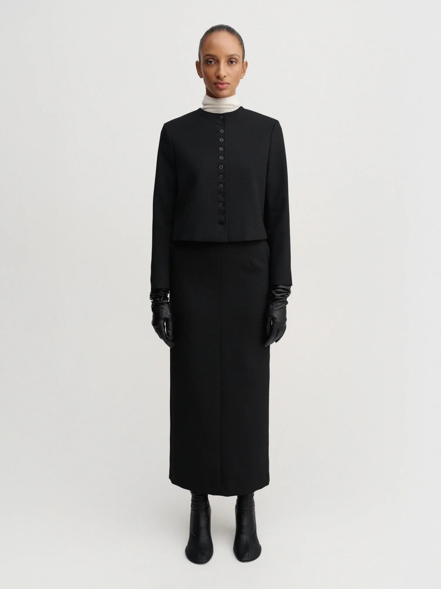 Person wearing a black outfit with a white background